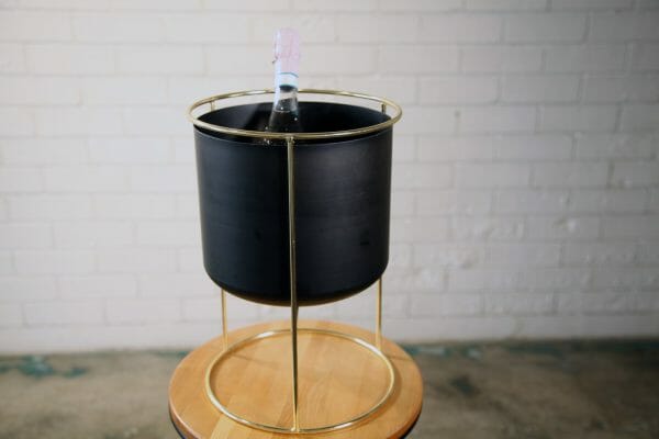 BLACK AND GOLD WINE BUCKET 01_resized A bottle of champagne sits in a modern black and gold bucket, embodying the elegance and joy of your next party event.