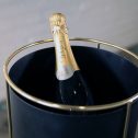A bottle of champagne displayed in a black bucket, featuring a refined gold stand for an elegant presentation at your wedding event.