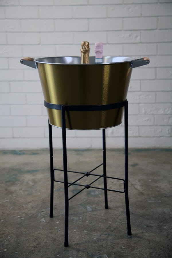 GOLD ICE BUCKETS - BLACK STAND 01_resized A stylish golden champagne bucket holds two bottles of champagne, elegantly displayed on a black stand for your next celebratory occasion.