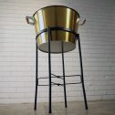 A sophisticated golden champagne bucket on a black stand, perfect for your special event or party.