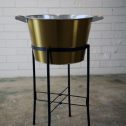 An elegant golden champagne bucket on a black stand, perfect for festive gatherings, event and party hire.