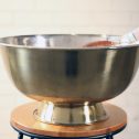 A large golden metal bowl, perfect for chilling drinks at your next party, wedding, or engagement celebration.