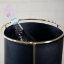 A bottle of champagne rests elegantly in a sleek black and gold bucket, showcasing a moment of celebration and luxury, perfect for your party or event.
