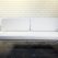 A stylish white couch with metal legs and a white cushion, perfect for events, available for hire from RSVP Event Hire in Perth.