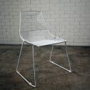 A stylish white wire dining chair with a metal frame and soft white cushion, perfect for any modern setting available from RSVP Event Hire in Perth.