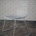 Trendy white wire dining chair with a metal frame and a comfy white cushion, a stylish addition to any decor, available from RSVP Event Hire in Perth.