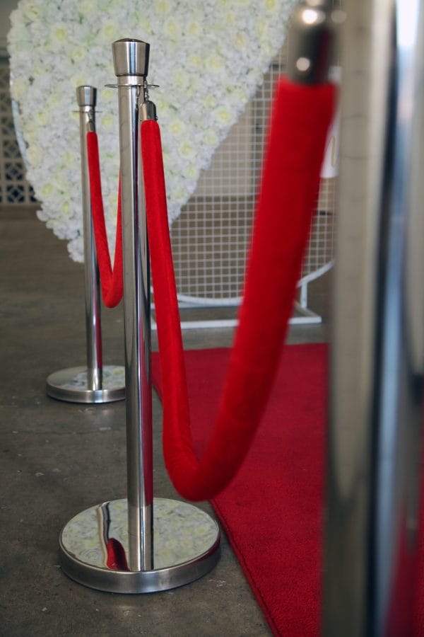 BOLLARDS 05_resize A vibrant red carpet laid out, surrounded by six stylish bollards for your next event, from RSVP Event Hire in Perth, creating an elegant entrance.