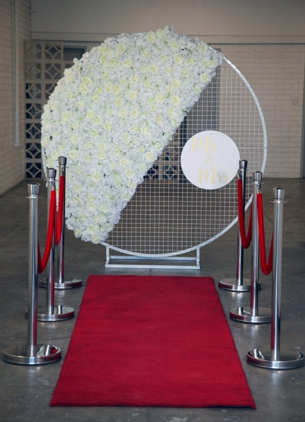 A striking red carpet and white flower backdrop, complemented by RSVP Event Hire's set of 6 Stylish Bollards, perfect for your next event in Perth.