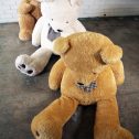 Three adorable giant teddy bears sitting on the floor, available for hire to make your event extra special from RSVP Event Hire.
