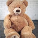 A giant teddy bear sitting on the floor, ready to bring joy to your event from RSVP Event Hire.