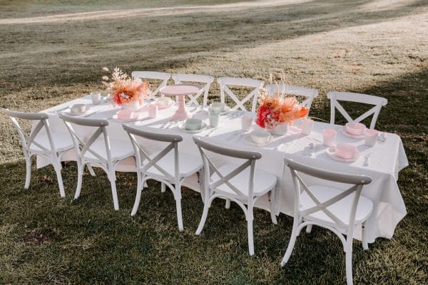 White-childrens-crossback-chairs-and-tables-for-hire-Kids-party-hire-Perth-RSVP Elegant table and white chairs adorned with pink flowers, designed for your Little One's event by RSVP Event Hire in Perth.