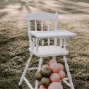 Elegant white high chair with pink and gold balloons, a lovely addition for events, available for hire in Perth.