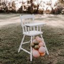 Charming white high chair adorned with pink and gold balloons, ideal for events, offered by RSVP Event Hire in Perth.